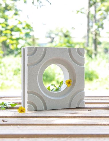 Gạch Thông Gió trắng lỗ tròn cong 4 góc để trên bàn gỗ